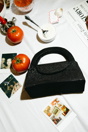 Beaded bag, tomatoes and polaroids on the table
