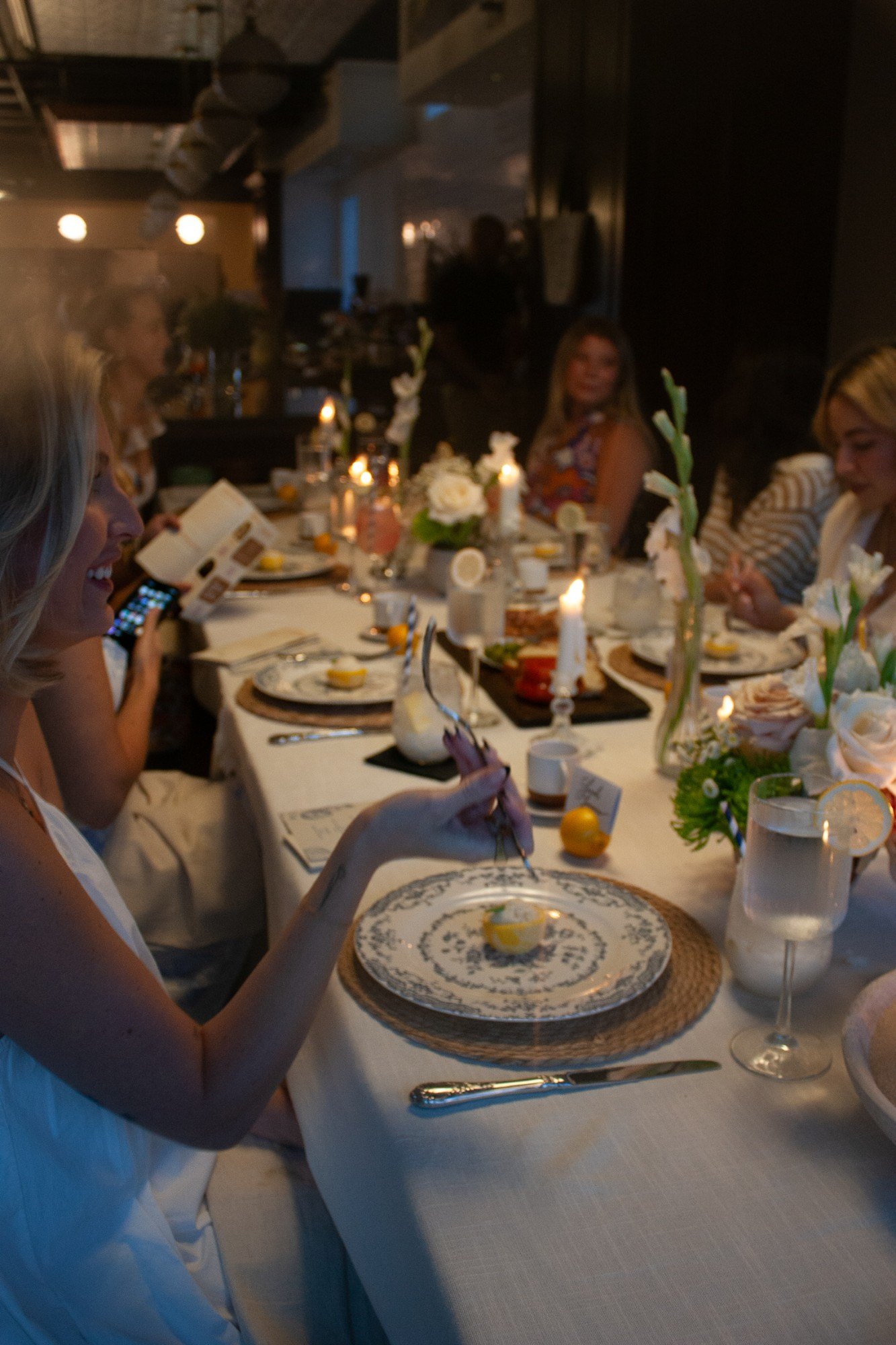 Guests enjoying the candlelit four course dinner down the long table