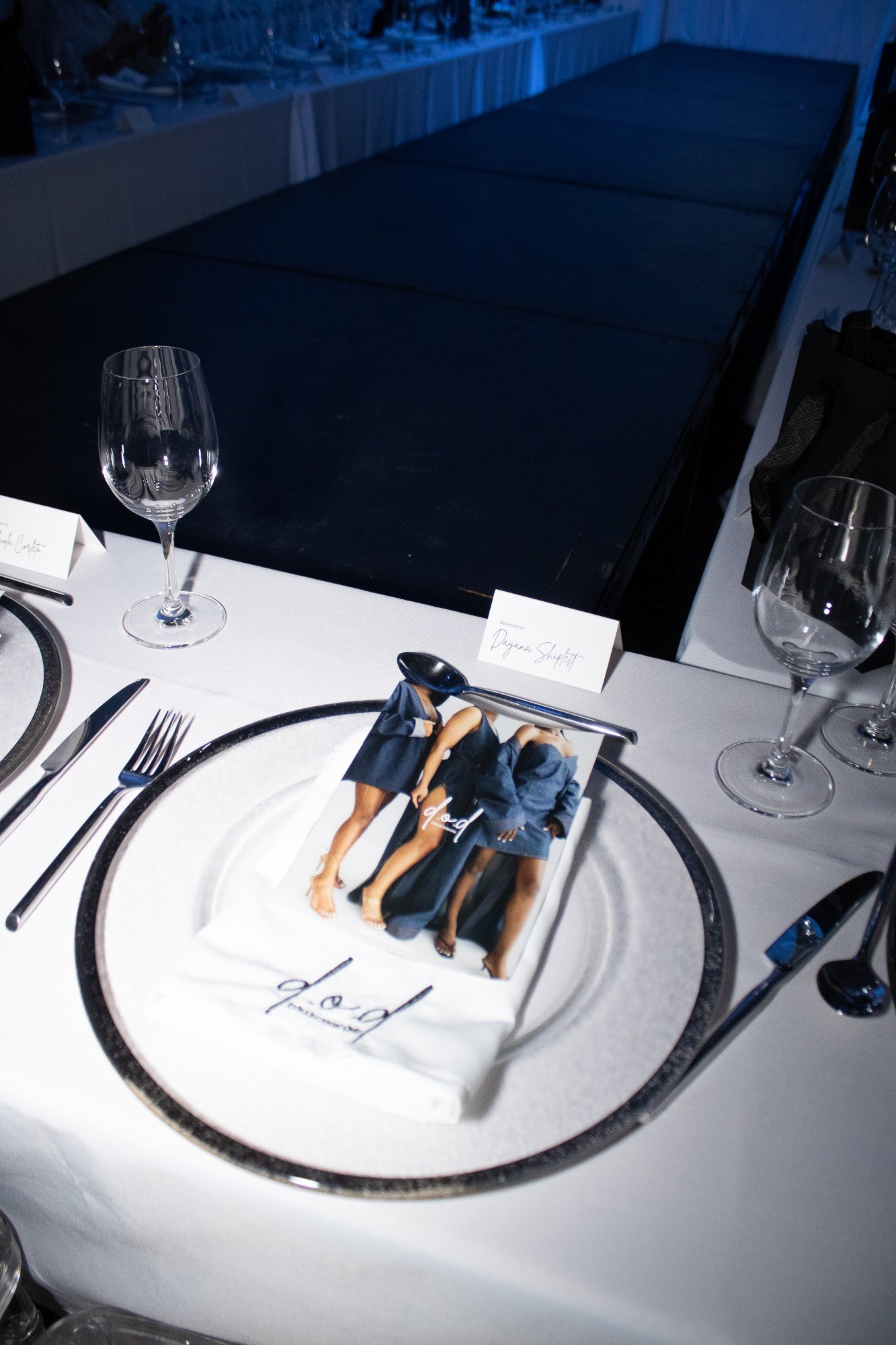 A d.o.d place setting with embroidered napkin beside the runway