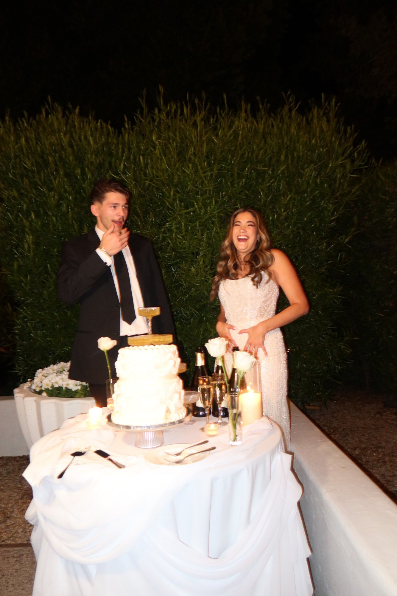The newlyweds laughing over the first taste of cake
