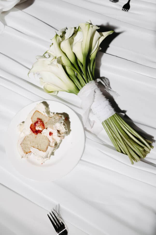 The bouquet and a slice of strawberry shortcake on white satin