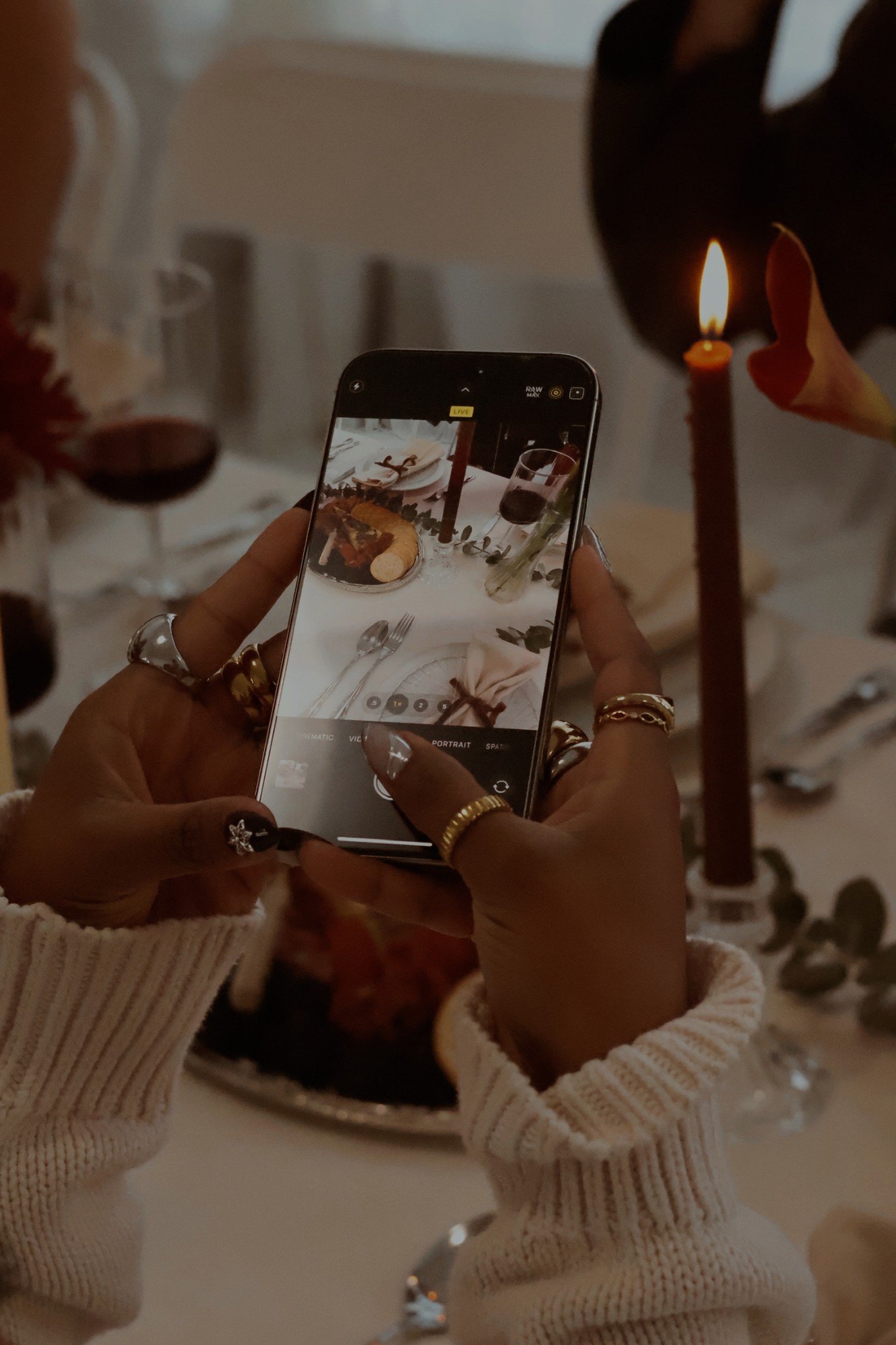 A guest photographs the tablescape on her phone by candlelight