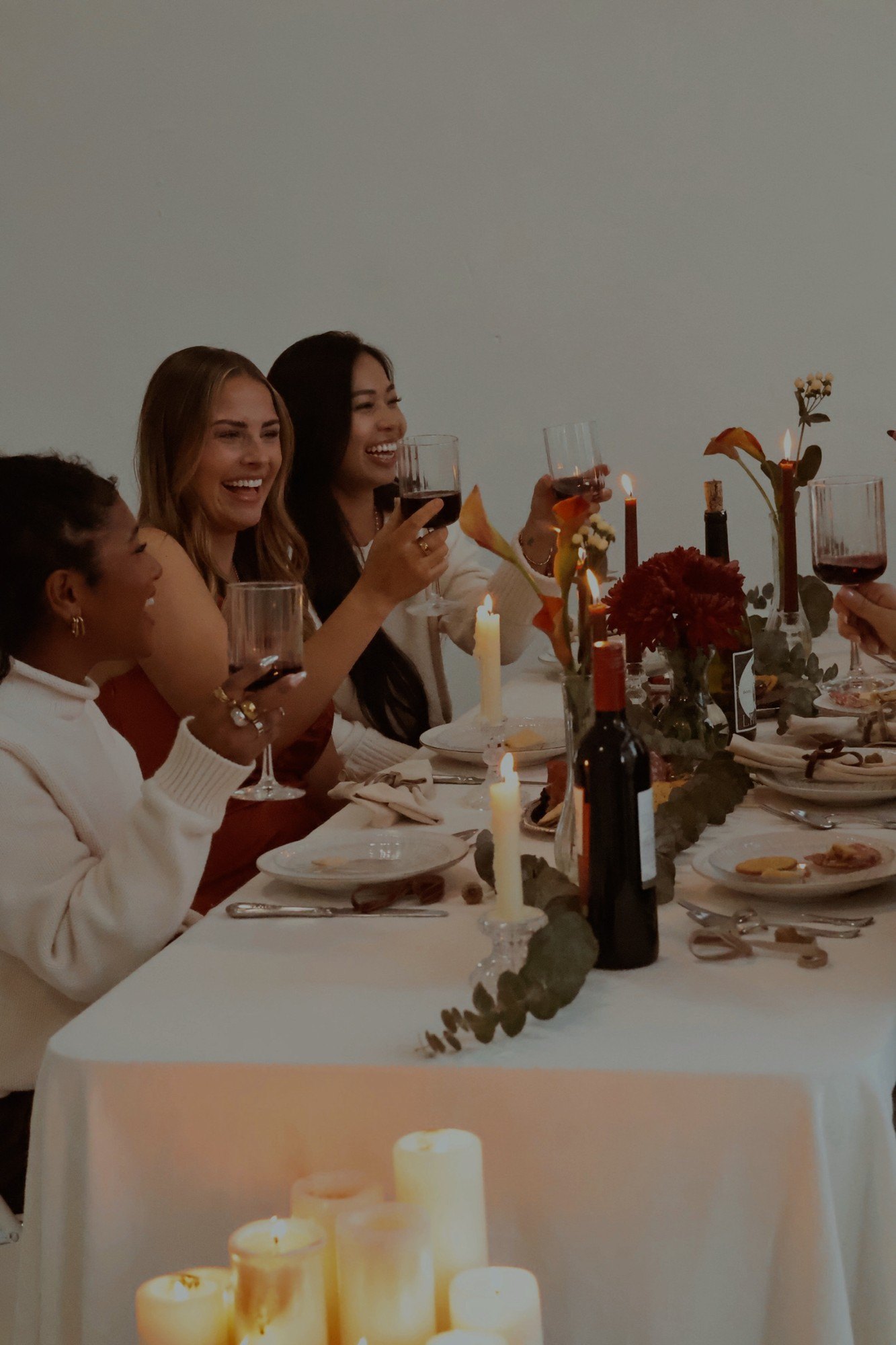 Guests raise their glasses down the eucalyptus-lined table