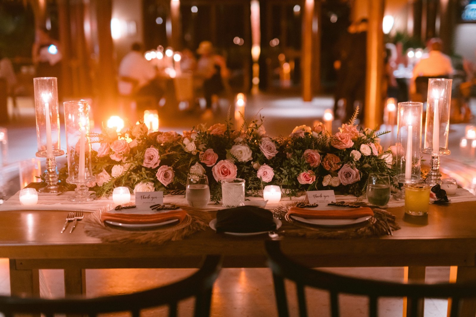 The candlelit sweetheart table draped in roses at the reception