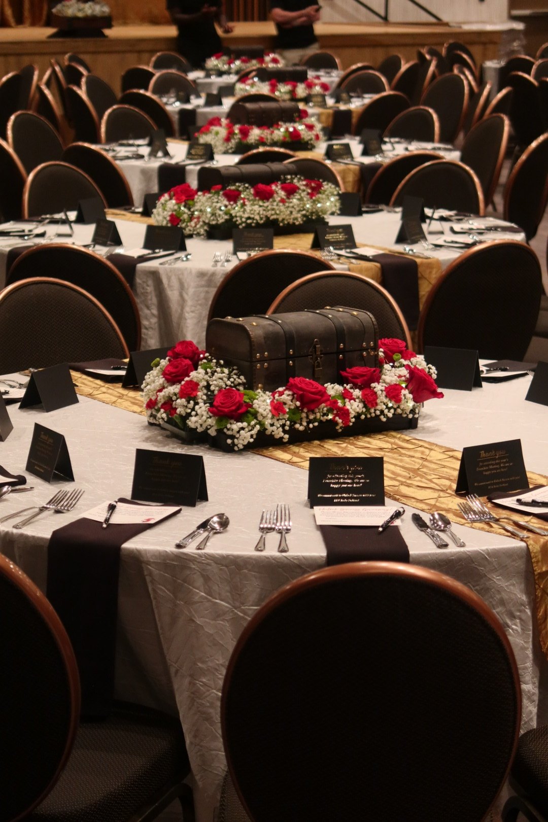 Round tables with treasure chest and rose centerpieces set for the franchise meeting